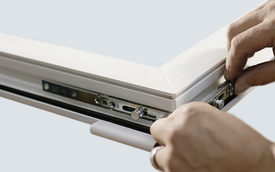 Hände justieren ein Fensterbeschlagsystem für verbesserten Raumkomfort bei der Nachrüstung.